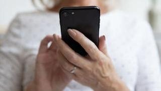 Frau hält Smartphone in der Hand