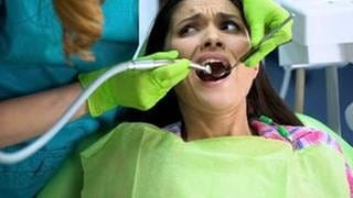 Ängstliche Frau beim Zahnarzt