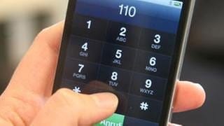Ein Mann hat in Mainz 66 mal innerhalt einer Stunde den Notruf 110 gewähauf einem Smartphone tippt eine Hand die 110 ein