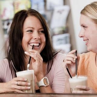 2 Frauen reden miteinander und trinken Kaffee