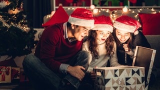 Familie beim Auspacken eines Weihnachtsgeschenks