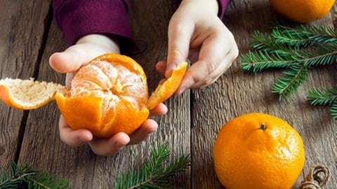 Mandarine wird geschält