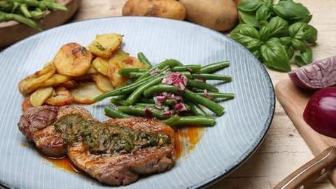 Schweinehalssteak mit Kräuterbutter und Bohnensalat