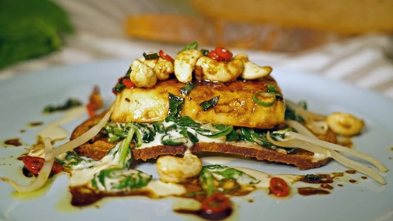 Gebratener Käse mit Parmesan-Spinat und Brotchips