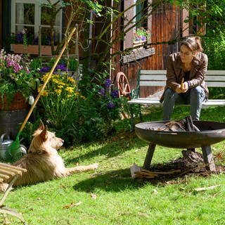 Franziska Hecker mit ihrem Hund Ramses vor ihrer Waldhütte