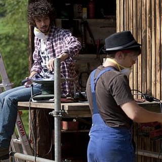 Albert und Sebastian schleifen ein großes Holztor ab