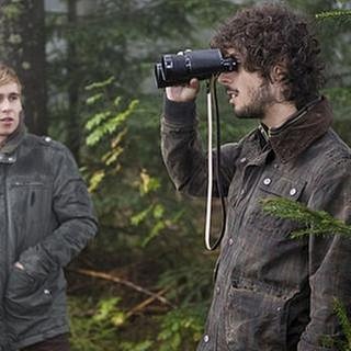 Sebastian und Albert im Wald, Albert schaut durch ein Fernglas