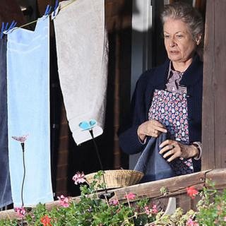 Johanna steht auf dem Balkon des Fallerhofes, neben ihr Wäsche an der Wäscheleine