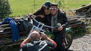 Toni fotografiert Ludwig und Sophie auf dem Motorrad, beide haben sich verkleidet