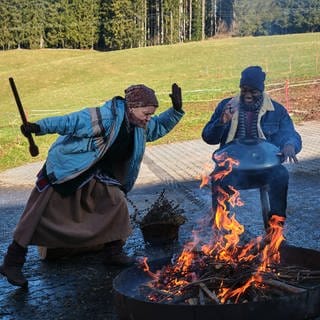 Lioba tanzt, Tayo spielt Handpan am Lagerfeuer hinter dem Fallerhof