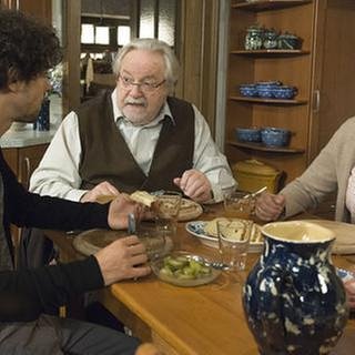 Albert, Hermann und Johanna beim Abendessen am Küchentisch