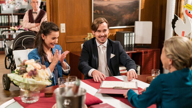 Jenny (Julia Obst), Sebastian (Dominik Stricker), Herr Weiss (Christoph Hagin) und Frau Heilert (Adelheid Theil) im für die standesamtliche Hochzeit vorbereiteten Bürgermeisterbüro