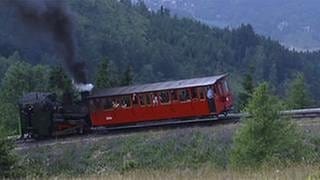 Lokomotive schiebt einen Wagon einen steilen Berg hinauf