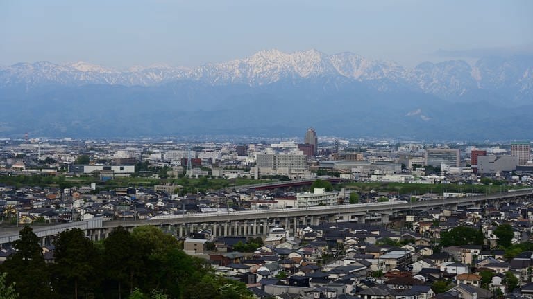 Die Großtstadt Toyama am Fuß des mehr als 3.000 Meter hohen Tateyama Gebirges.