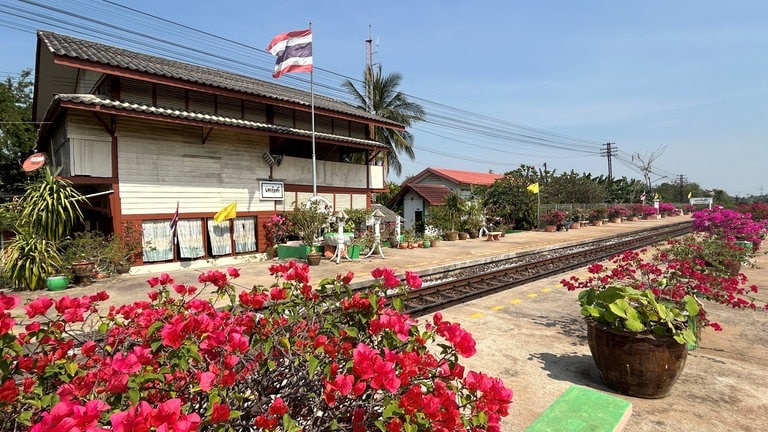 Blumengeschmückte Bahnhöfe säumen die Strecke von Thonburi nach Nam Tok.