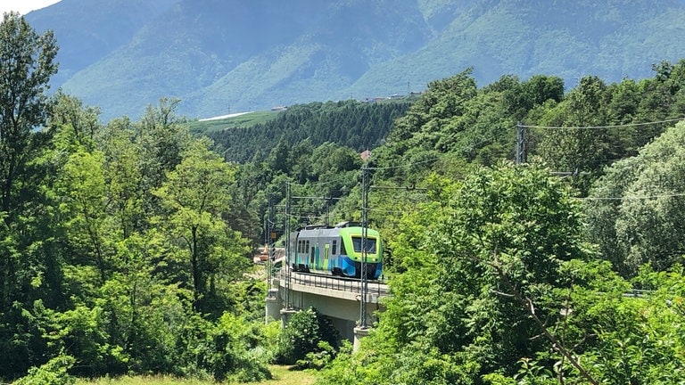 Auf der Hochebene des Nonstal begleiten den Zug die Berge der Brenta-Gruppe – sie gehören zum UNESCO-Weltnaturerbe.