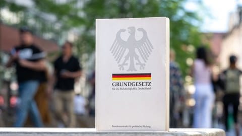  Ein Grundgesetz steht in einer Fußgängerzone in Leipzig. Das Grundgesetz der Bundesrepublik feiert in diesem Jahr seinen 75. Geburtstag. Es wurde am 23. Mai 1949 erlassen.