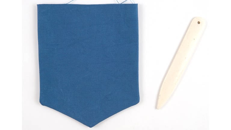 Die Taschenklappe auf rechts wenden und die Ecken mithilfe eines stumpfen Gegenstands (z.B. Stricknadel oder Ende eines Borstenpinsels) sorgfältig ausformen.