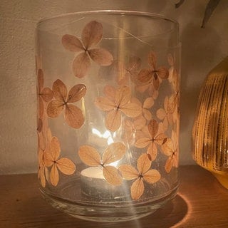 Die laminierte Folie dient nun als Manschette für eine Vase oder ein Glas. Die Breite oder Höhe der Folie kann mit der Schere angepasst werden. Die Manschette am Schluss mit etwas transparentem Klebefilm verschließen. 