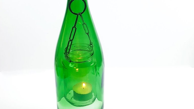 Ein Teelicht ins Glas stellen und die Metallkette von unten durch die abgeschnittene Glasflasche nach oben ziehen. Das Marmeladenglas schwebt nun in der Flasche.