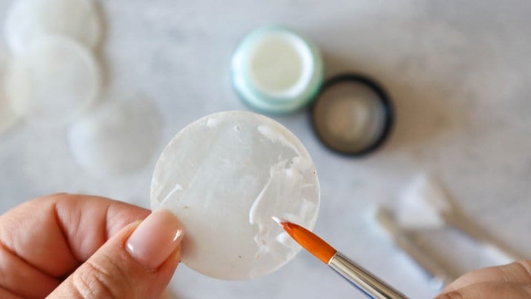 Perlmuttschieben vergolden – hierzu die Anlegemilch dünn auf die Schreibe auftragen und austrocknen lassen. Wenn die Milch ausgetrocknet ist, wird sie durchsichtig. Die Oberfläche der Muschelscheibe ist nun leicht klebend. 