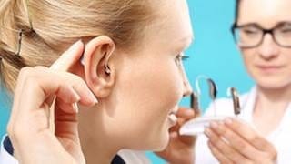 Frau kriegt ein passendes Hörgerät von einer Ärztin