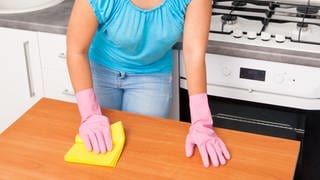 Frau putzt die Spüele für Hygiene in der Küche