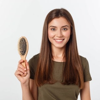 Frau mit Haarbürste in der Hand