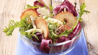 Salatschüssel mit Endiviensalat, Chicoree und Brot