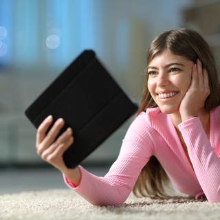 Frau hält Tablet - Online Bücher ausleihen
