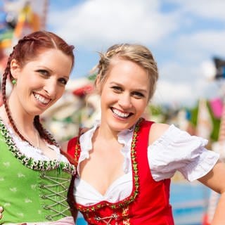 Zwei junge Frauen im Dirndl -  das perfekt Trachten-Outfit fürs Volksfest