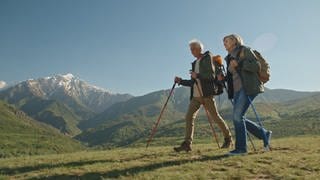 Mann und Frau beim Nordic Walking - Fitness in den Bergen