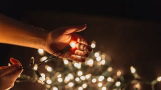 Hand mit Lichterkette - die richtige Weihnachtsbeleuchtung