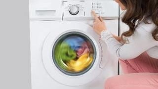 Eine Frau neben einer Waschmaschine