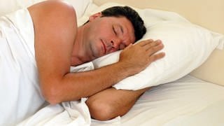 Mann schläft auf einem Kopfkissen - Materialien, Form und Pflege für ihr Kopfkissen