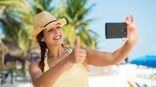Eine Frau macht ein Selfie an einem Strand - Tipps und Tricks zur Gestaltung von guten Fotos