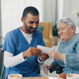 Krankenpfleger hilft älterer Frau - Checkliste plötzlich pflegebedürftig