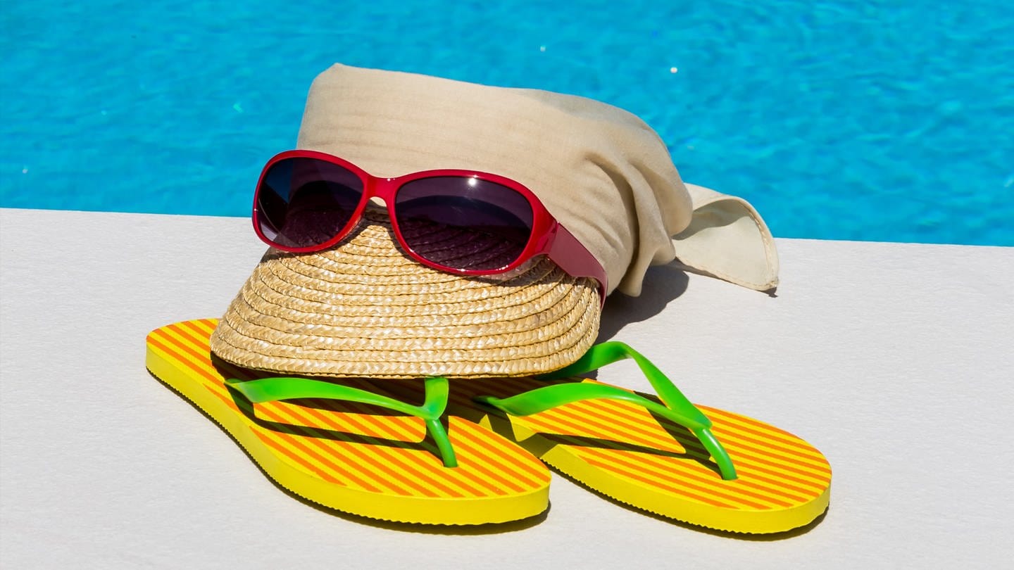 Sonnenbrille mit Strohut am Schwimmbad - Schutz vor UV-Strahlen