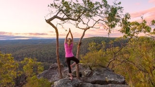 Frau macht Pilates auf dem Berg