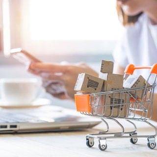 Frau sitzt vor dem PC und bestellt beim Onlineshopping