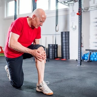 Mann beugt das Knie im Gym - Knieschmerzen müssen nicht sein