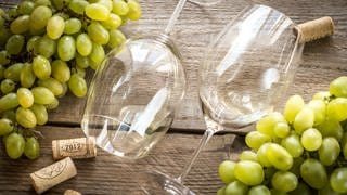 Weingläser mit Trauben und Weinkorken