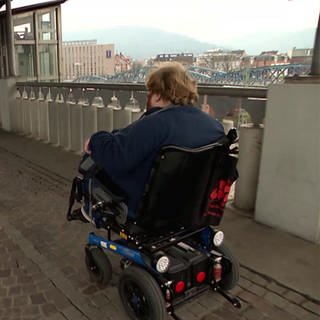 Rollstuhlfahrer an einem Bahnhof