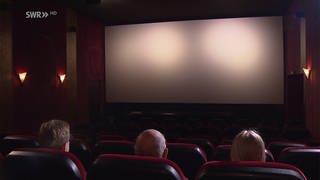 Drei Menschen sitzen in einem Kino