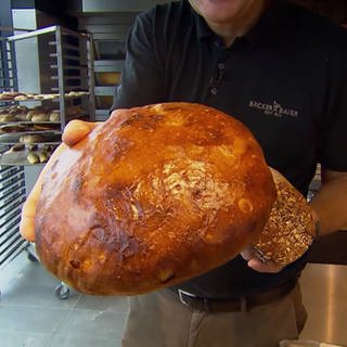 Jochen Baier präsentiert frisch gebackenes Brot