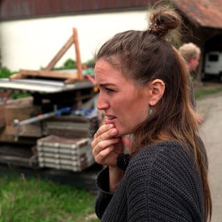 Geraldine Schüle schaut nachdenklich auf eine Baustelle auf ihrem Bauernhof