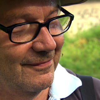 Mann mit einer Stechmücke auf der Wange in Ketsch am Rhein