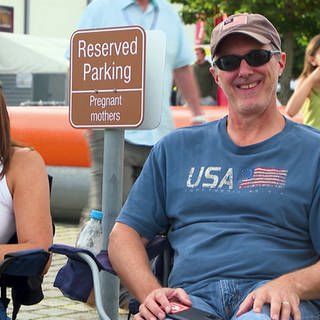 In der US-Kaserne in Böblingen wird der amerikanische Nationalfeiertag gefeiert. Eine Frau und ein Mann sitzen auf Stühlen und freuen sich.