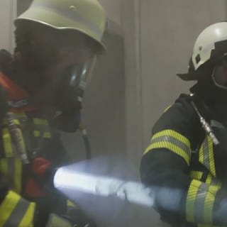 Zwei Feuerwehrazubis in Feuerwehrausrüstung