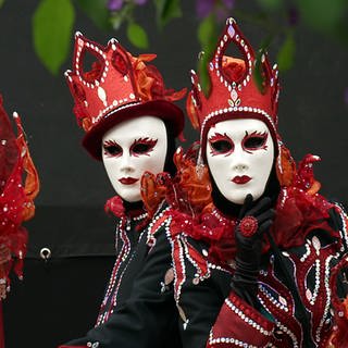 Zwei Besucher der Venezianischen Messe in Ludwigsburg tragen Masken und Kostüme.